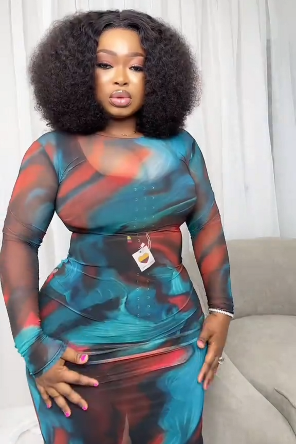 Femme portant une combinaison gainante sous une robe moulante bleu et rouge.